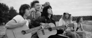 Viktor (Teo Yoo) und Leonid (Filipp Avdeyev) spielen ihre Songs am Strand vor.